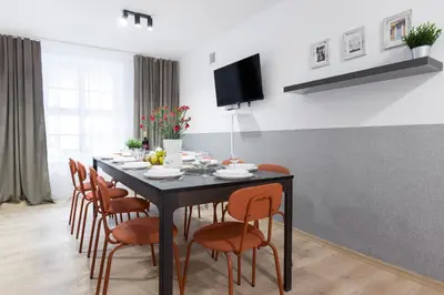 a dining room with a black table and orange chairs at Józefa 12 Apartments in Kraków