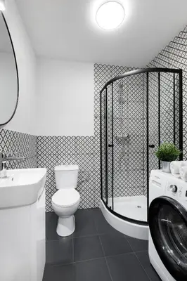 a bathroom with a toilet and a sink and a washing machine at Józefa 12 Apartments in Kraków