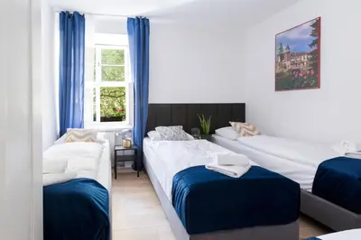 a bedroom with two beds and a mirror at Józefa 12 Apartments in Kraków