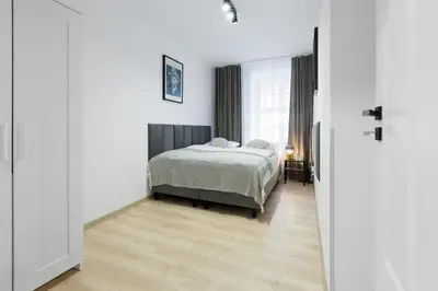 a bedroom with a bed and a large window at Józefa 12 Apartments in Kraków