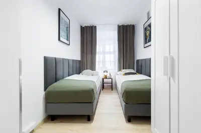 a room with two beds and a window at Józefa 12 Apartments in Kraków