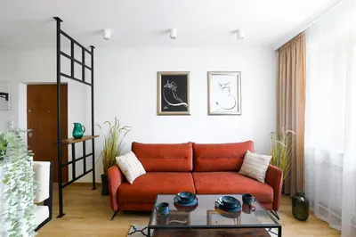 a living room with a red couch and a table at Cozy studio with Air Conditioning for couples, Old Town - Jewish District in Kraków