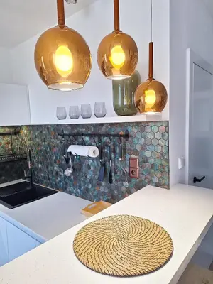 a kitchen with three lights hanging over a counter at Cozy studio with Air Conditioning for couples, Old Town - Jewish District in Kraków