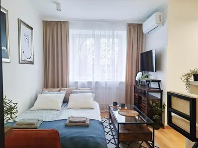 a living room with a couch and a tv at Cozy studio with Air Conditioning for couples, Old Town - Jewish District in Kraków