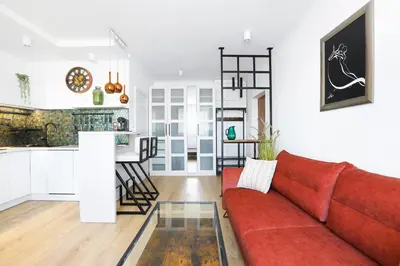 a living room with a red couch and a kitchen at Cozy studio with Air Conditioning for couples, Old Town - Jewish District in Kraków