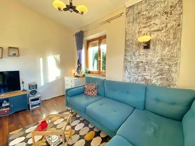 a living room with a blue couch and a tv at Luxury, spacious apartament with two bedrooms and balcony in Przybysławice