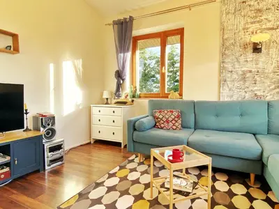 a living room with a blue couch and a tv at Luxury, spacious apartament with two bedrooms and balcony in Przybysławice