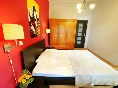 a bedroom with a large bed and a red wall at Luxury, spacious apartament with two bedrooms and balcony in Przybysławice