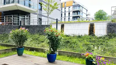 three potted plants inront of a fence with flowers at Classy 2-room Apartment with Private Garden and Air Conditioning- Old Town in Kraków