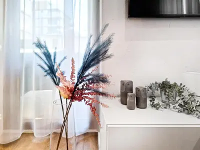 a table with a vase with a plant on it at Classy 2-room Apartment with Private Garden and Air Conditioning- Old Town in Kraków