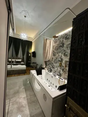 a large bathroom with a tub and a bedroom at Jacuzzi Berka Apartamenty in Kraków