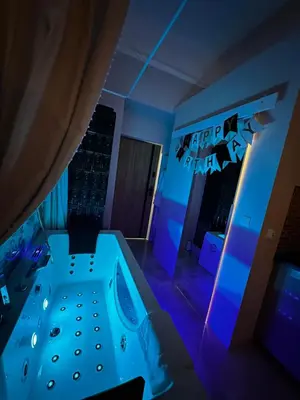 a room with a jacuzzi tub in a room with purple lights at Jacuzzi Berka Apartamenty in Kraków