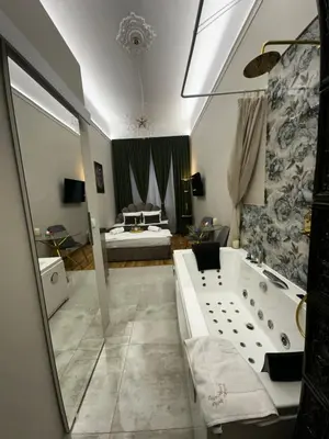 a bathroom with a tub and a bedroom with a bed at Jacuzzi Berka Apartamenty in Kraków