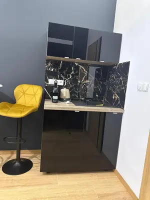 a small desk with a yellow chair in a room at Jacuzzi Berka Apartamenty in Kraków