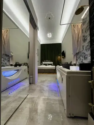 a large bathroom with a sink and a bed in the background at Jacuzzi Berka Apartamenty in Kraków