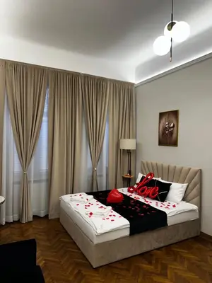 a bedroom with a bed with red roses on it at Jacuzzi Berka Apartamenty in Kraków