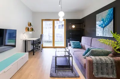 a living room with a couch and a table at Modern apt next to train station in Kraków
