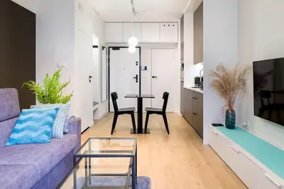a living room with a purple couch and a table at Modern apt next to train station in Kraków