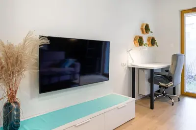 a living room with a large flat screen tv on a wall at Modern apt next to train station in Kraków