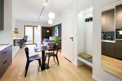 a kitchen and dining room with a table and chairs at Modern apt next to train station in Kraków