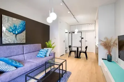 a living room with a purple couch and a table at Modern apt next to train station in Kraków