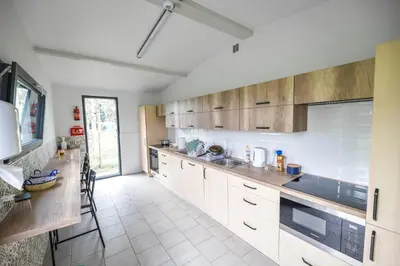 a kitchen with white cabinets and a large window at KempingZator Glamping in Zator