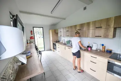 a woman standing in a kitchen preparing food at KempingZator Glamping in Zator