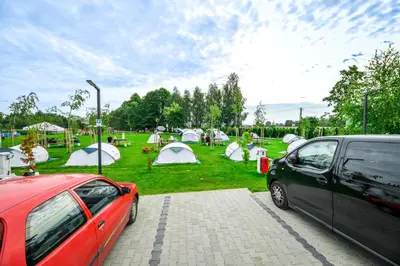 two cars parked in front of a park with tents at KempingZator Glamping in Zator