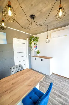 a kitchen with a wooden table and blue chairs at KempingZator Glamping in Zator