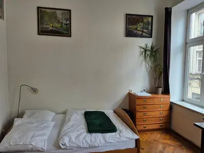 a bedroom with a bed and a dresser and a window at Agnieszki Pokoj nr 2 in Kraków
