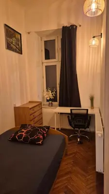 a bedroom with a bed and a desk and a chair at Agnieszki Pokoj nr 3 in Kraków
