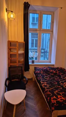 a bedroom with a bed and a chair and a window at Agnieszki Pokoj nr 3 in Kraków