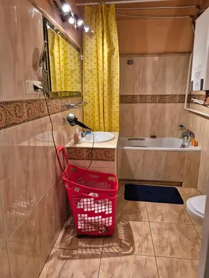 a bathroom with a sink and a red basket at Agnieszki Pokoj nr 3 in Kraków