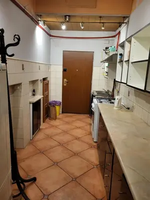 a large kitchen with a tile floor and a door at Agnieszki Pokoj nr 3 in Kraków