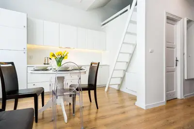 a kitchen and dining room with a glass table and chairs at Apartament Felicjanek in Kraków
