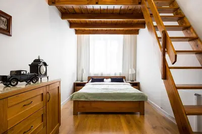 a bedroom with a bed and a stair case at Apartament Felicjanek in Kraków