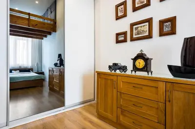 a bathroom with a sink and a clock on a counter at Apartament Felicjanek in Kraków