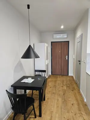 a room with a black table and chairs and a door at Apartamenty Orawska 14 in Kraków