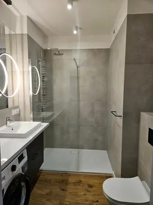 a bathroom with a shower and a toilet and a sink at Apartamenty Orawska 14 in Kraków