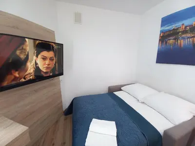 a bedroom with a bed and a flat screen tv at Old Town Apartmens - B33 in Kraków