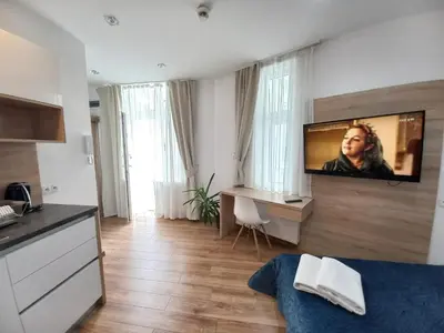 a hotel room with a television on a wall at Old Town Apartmens - B33 in Kraków
