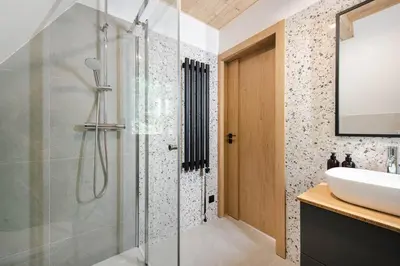 a bathroom with a glass shower and a sink at Budzi nas las Marcyporęba - Duży domek in Marcyporęba