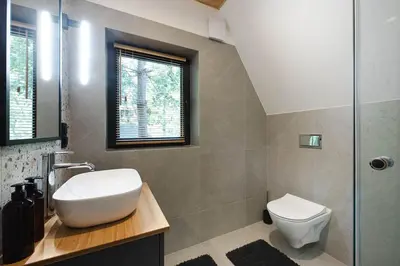 a bathroom with a sink and a toilet at Budzi nas las Marcyporęba - Duży domek in Marcyporęba