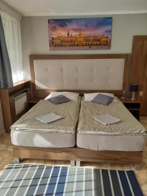 a bedroom with two beds and a painting on the wall at Mini Apartamenty Centrum in Kraków