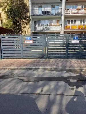 a gate in front of a building with a fence at Mini Apartamenty Centrum in Kraków