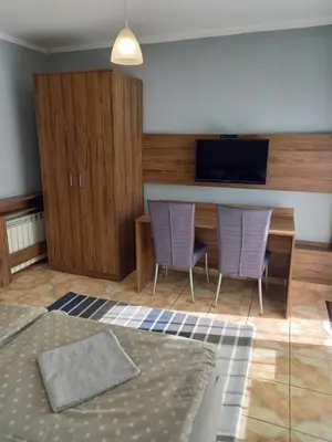 a bedroom with two purple chairs and a desk with a television at Mini Apartamenty Centrum in Kraków