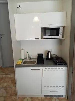a small kitchen with a sink and a microwave at Mini Apartamenty Centrum in Kraków