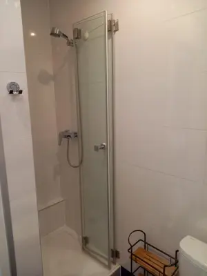 a shower with a glass door in a bathroom at Mini Apartamenty Centrum in Kraków