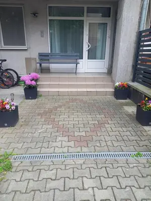 a bench in front of a house with flowers at Mini Apartamenty Centrum in Kraków