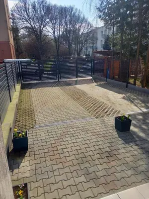 a brick patio with two potted plants and a fence at Mini Apartamenty Centrum in Kraków